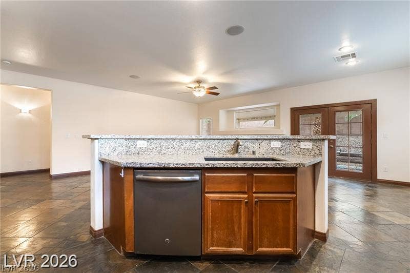 10605 Bardilino Street, Las Vegas, NV 89141 Rich stone-textured flooring and premium granite counters anchor this open and functional kitchen space.