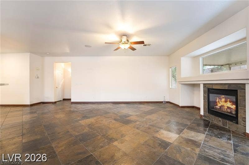 10605 Bardilino Street, Las Vegas, NV 89141 Rich tile flooring and a built-in fireplace with slate accents anchor this versatile room.