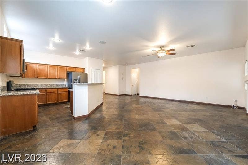 10605 Bardilino Street, Las Vegas, NV 89141 Stone tile flooring flows through the open-plan layout connecting the kitchen and living areas.