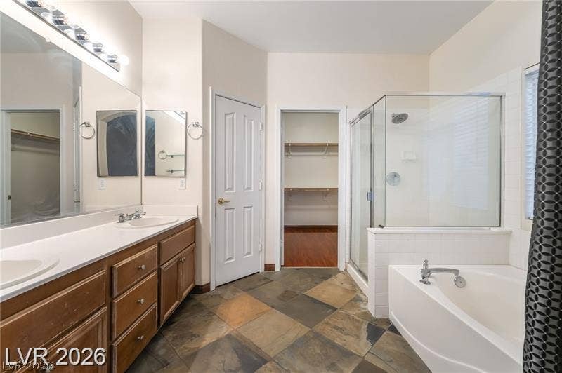 10605 Bardilino Street, Las Vegas, NV 89141 Natural slate floors ground this private bath complete with a soaking tub and glass shower.