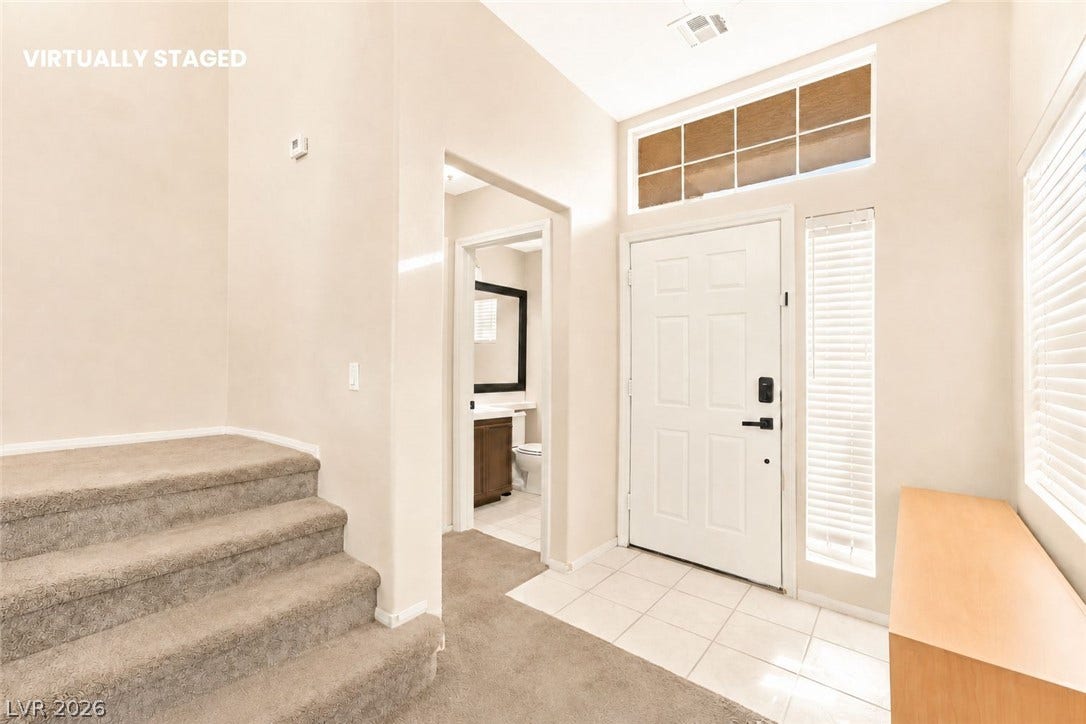 1874 Mesquite Canyon Drive, Henderson, NV 89012 A bright entryway features high ceilings, tiled floors, and a carpeted staircase.