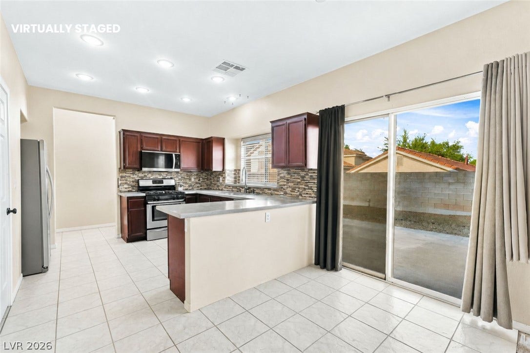 1874 Mesquite Canyon Drive, Henderson, NV 89012 Tile flooring and sliding glass doors enhance this functional kitchen layout.