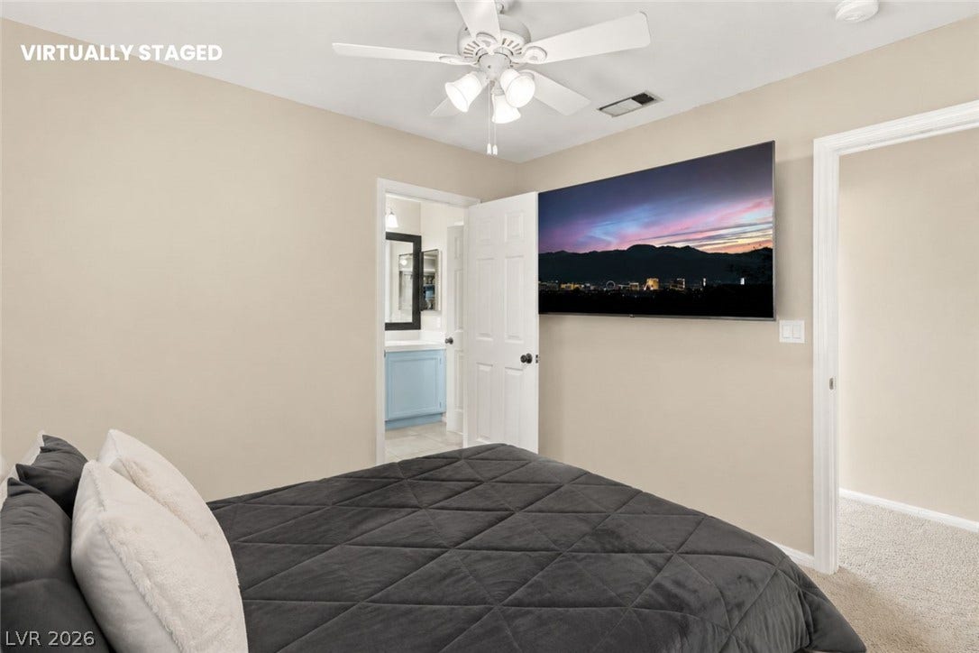 1874 Mesquite Canyon Drive, Henderson, NV 89012 Smooth plaster walls and neutral carpet underfoot define this secondary bedroom with adjoining bath.