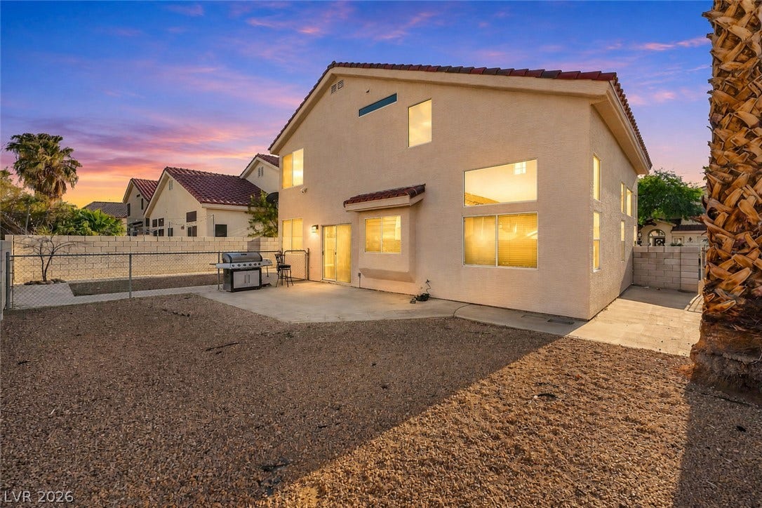 1874 Mesquite Canyon Drive, Henderson, NV 89012 A spacious backyard patio area sits behind this two-story home under a twilight sky.