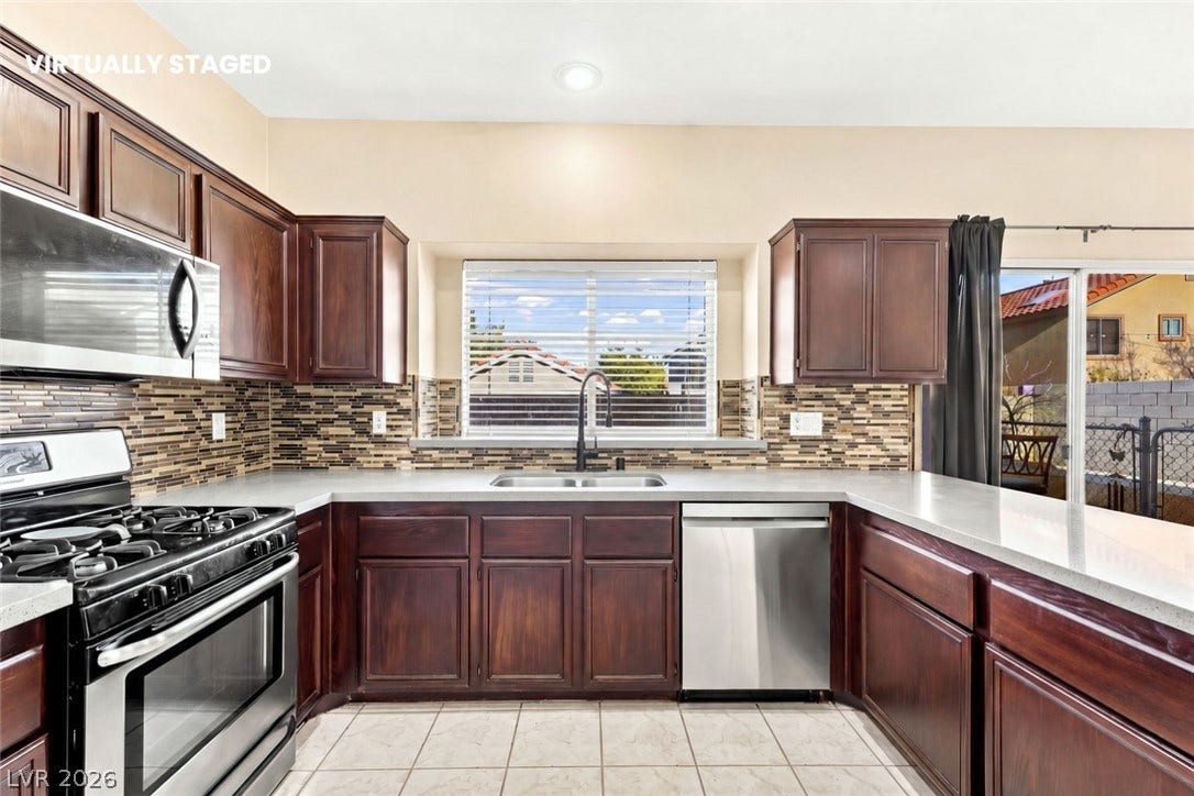 1874 Mesquite Canyon Drive, Henderson, NV 89012 Rich wood cabinetry surrounds integrated appliances on durable tile flooring.