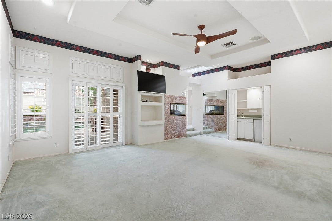 2212 Chatsworth Court, Henderson, NV 89074 A spacious living area offers a coffered ceiling, ceiling fan, and built-in features, with a convenient wet bar nearby.