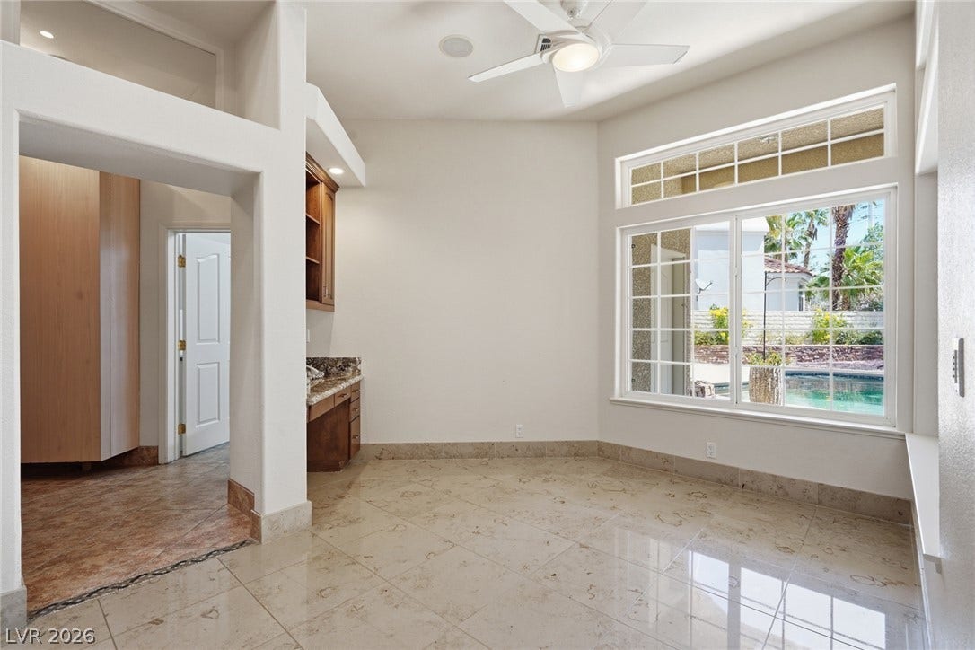 2212 Chatsworth Court, Henderson, NV 89074 A versatile bonus room offers ample space, bathed in natural light, with a built-in desk and pool view.