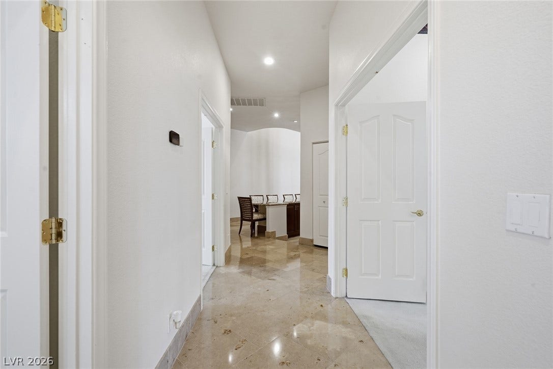 2212 Chatsworth Court, Henderson, NV 89074 A well-lit corridor welcomes you home, showcasing sleek tile flooring and convenient recessed lighting.