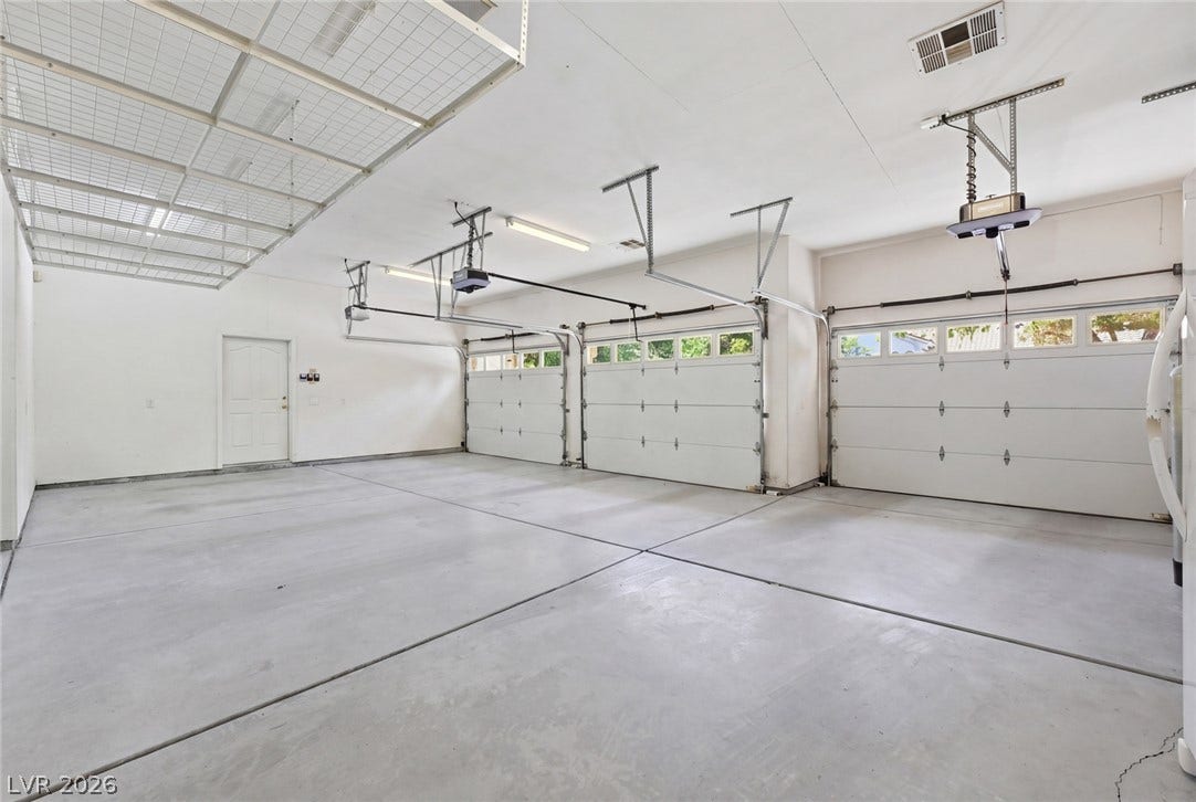 2212 Chatsworth Court, Henderson, NV 89074 A spacious garage features three overhead doors and ample room for vehicles and storage.