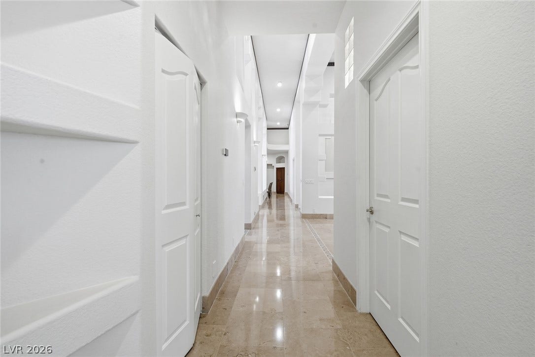 2212 Chatsworth Court, Henderson, NV 89074 Reflective tiled flooring spans this pristine hallway, leading to well-lit interior spaces.