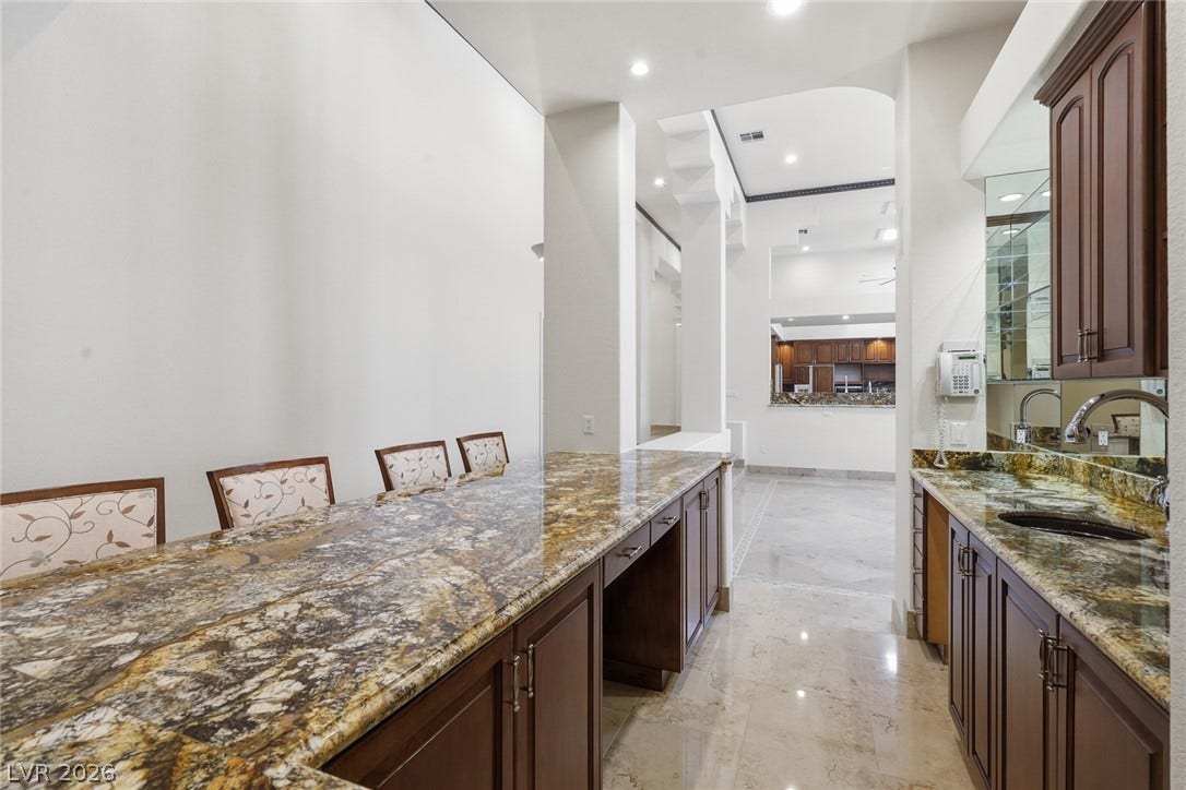 2212 Chatsworth Court, Henderson, NV 89074 A well-appointed wet bar with luxurious granite counters, ready for entertaining.