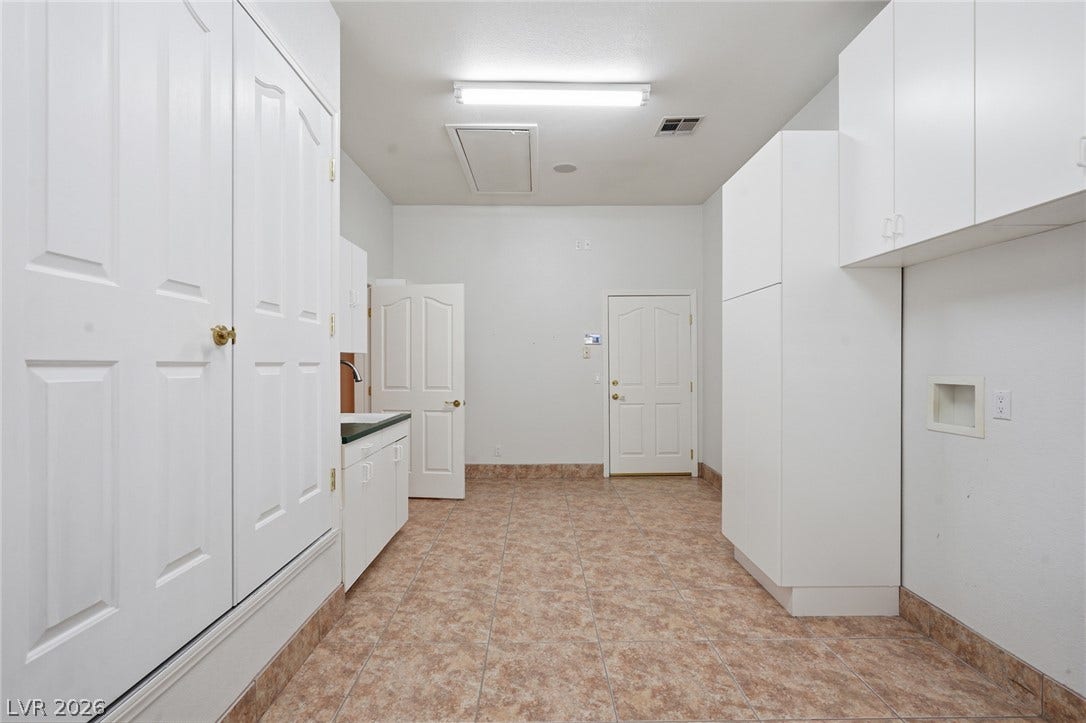 2212 Chatsworth Court, Henderson, NV 89074 Ample storage cabinetry and utility connections offer functional efficiency in this well-appointed laundry space.