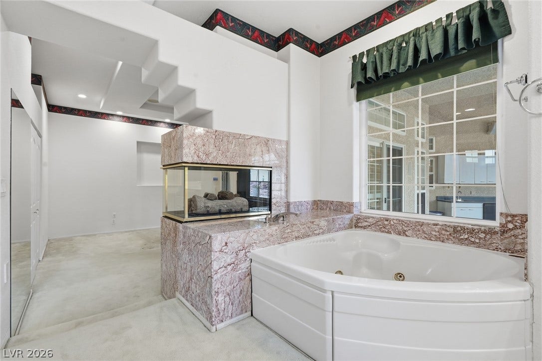 2212 Chatsworth Court, Henderson, NV 89074 Indulge in a corner jetted tub and a stylish two-sided fireplace, creating a serene and private retreat.