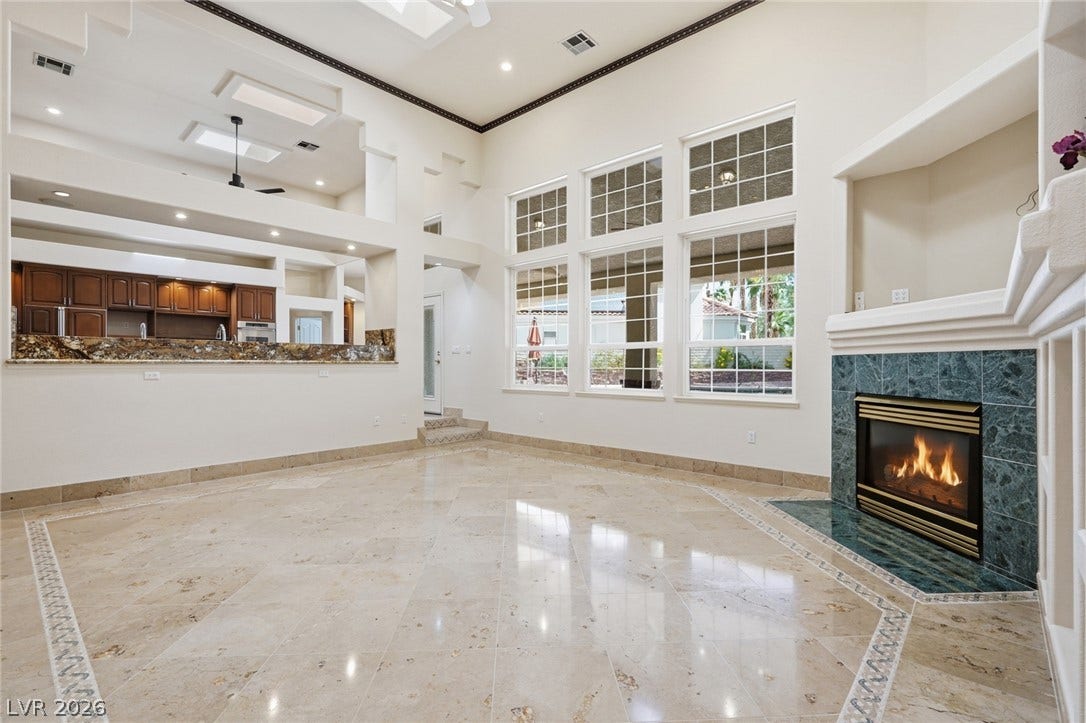 2212 Chatsworth Court, Henderson, NV 89074 A spacious living area features a grand fireplace and towering windows.