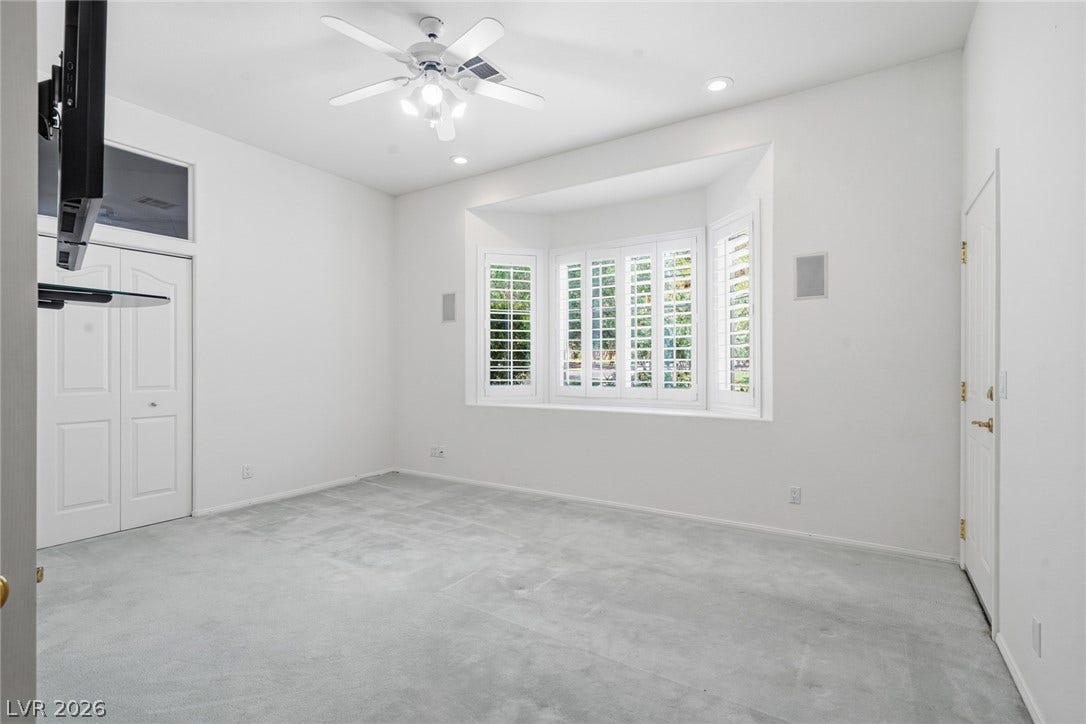 2212 Chatsworth Court, Henderson, NV 89074 Well-lit living area features a bay window with shutters and soft carpeting.