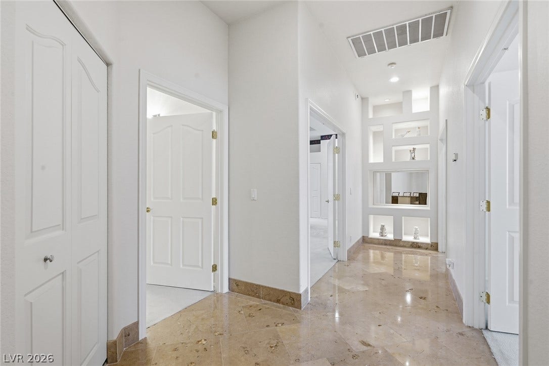 2212 Chatsworth Court, Henderson, NV 89074 A well-lit corridor with recessed lighting and built-in shelving showcases elegant flooring.