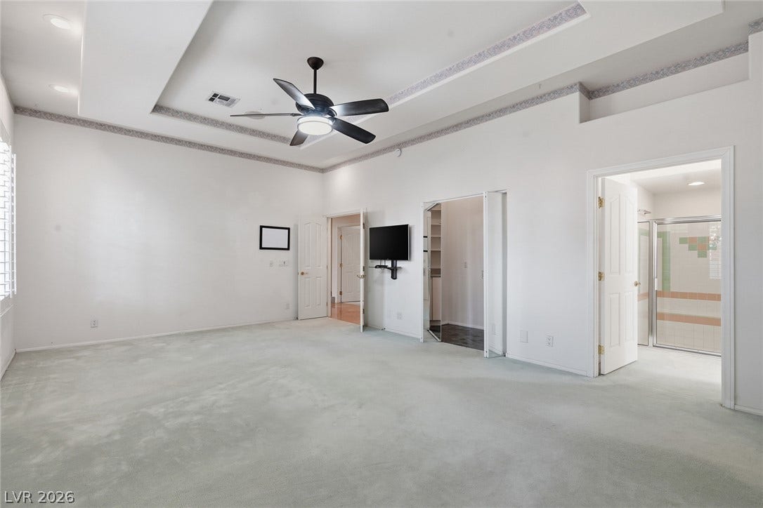 2212 Chatsworth Court, Henderson, NV 89074 A spacious primary bedroom features soft carpeting, recessed lighting, and a ceiling fan.
