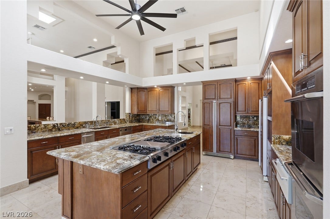 2212 Chatsworth Court, Henderson, NV 89074 Culinary adventures await in this gourmet kitchen featuring a vast central island and elegant stone countertops.