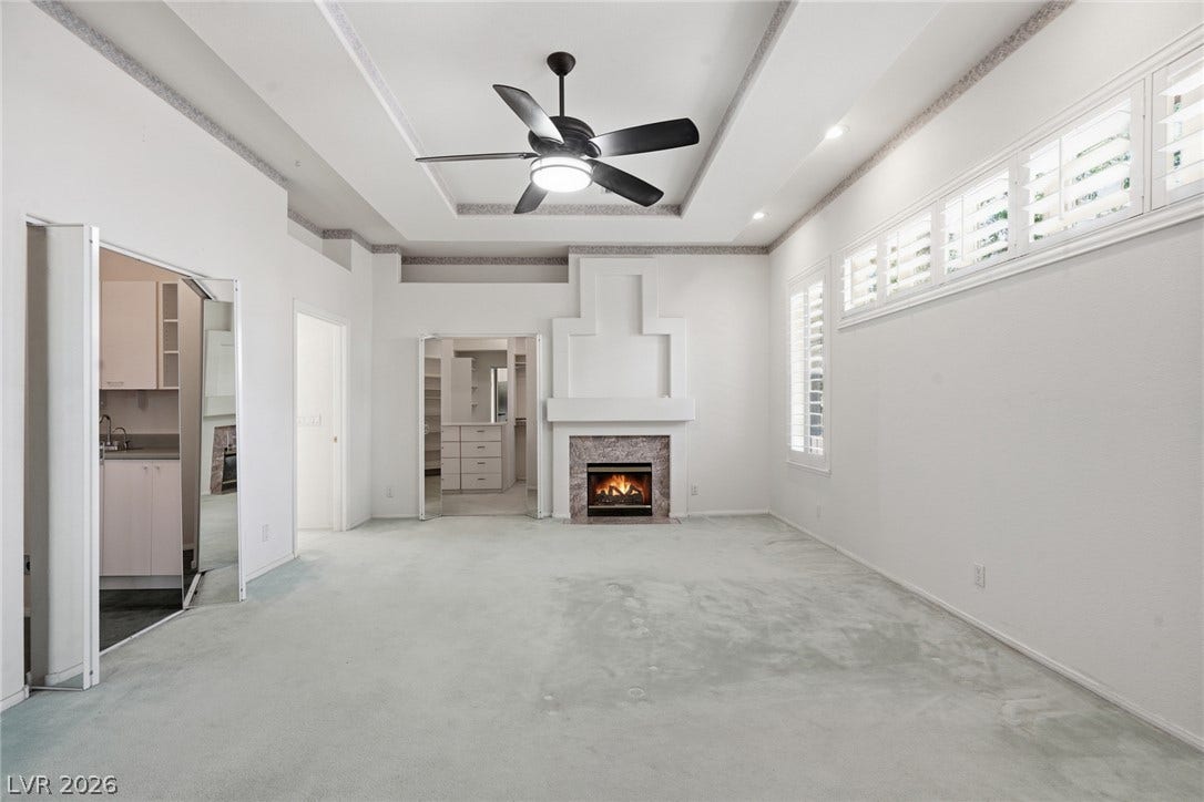2212 Chatsworth Court, Henderson, NV 89074 A tray ceiling with a modern ceiling fan complements the elegant fireplace and ample natural light from louvered windows.