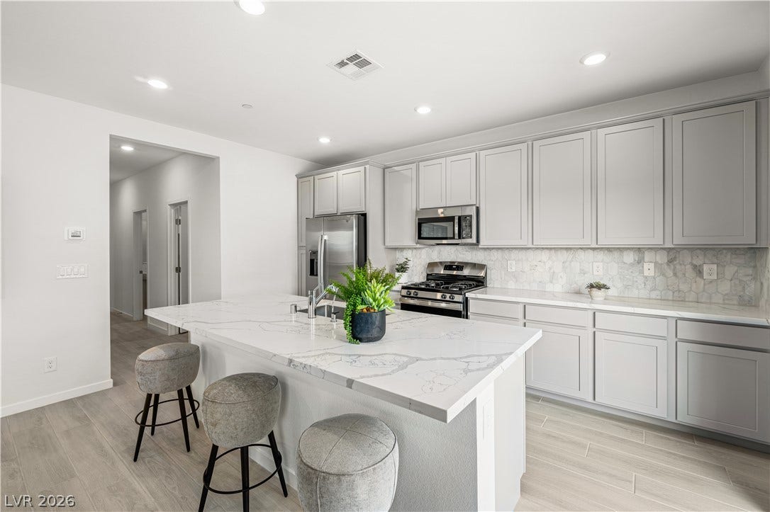 132 Harper Crest Avenue, Henderson, NV 89011 Streamlined cabinetry and veined stone countertops anchor this modern culinary workspace.