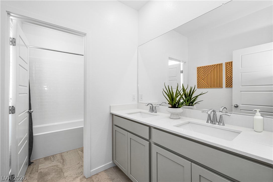 132 Harper Crest Avenue, Henderson, NV 89011 Double vanities with clean white countertops face a spacious shower and tub combination area.