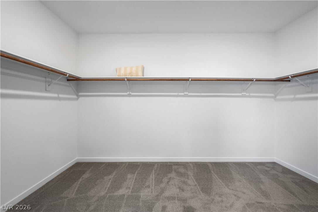 132 Harper Crest Avenue, Henderson, NV 89011 Ample hanging rods and shelving wrap around this carpeted walk-in closet.