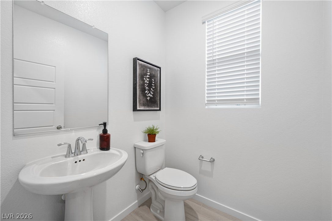 132 Harper Crest Avenue, Henderson, NV 89011 Clean lines and wood-look flooring define this powder room with a classic pedestal sink.
