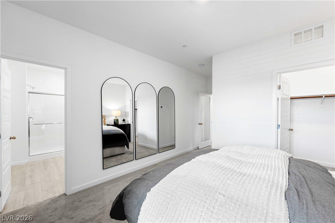 132 Harper Crest Avenue, Henderson, NV 89011 Plush carpeting and crisp white walls define this primary suite with an adjacent bath.