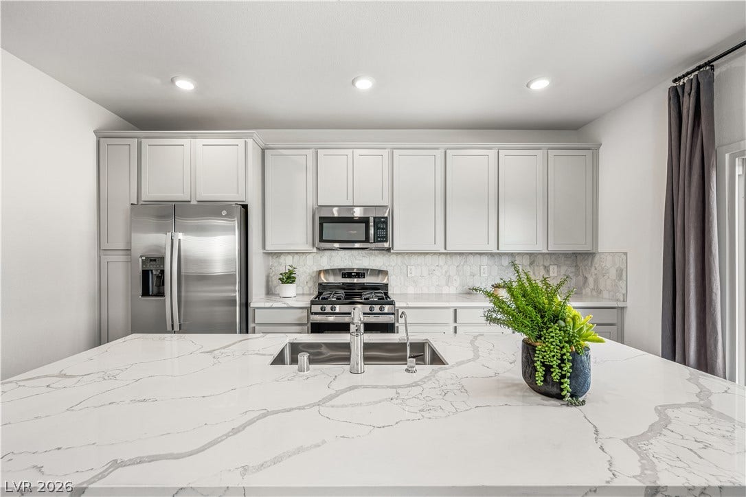 132 Harper Crest Avenue, Henderson, NV 89011 Polished stone countertops and seamless built-in cabinetry define this modern culinary workspace.