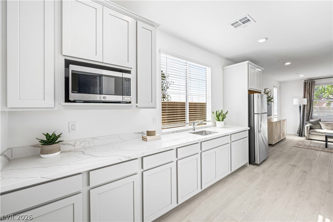 132 Harper Crest Avenue, Henderson, NV 89011 Gleaming stone countertops and shaker cabinetry line this light-filled modern culinary space.