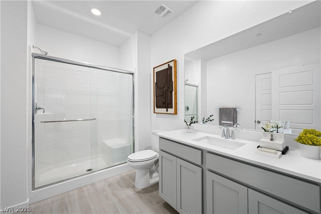 132 Harper Crest Avenue, Henderson, NV 89011 Clean lines and modern finishes define this bathroom complete with a glass-enclosed walk-in shower.