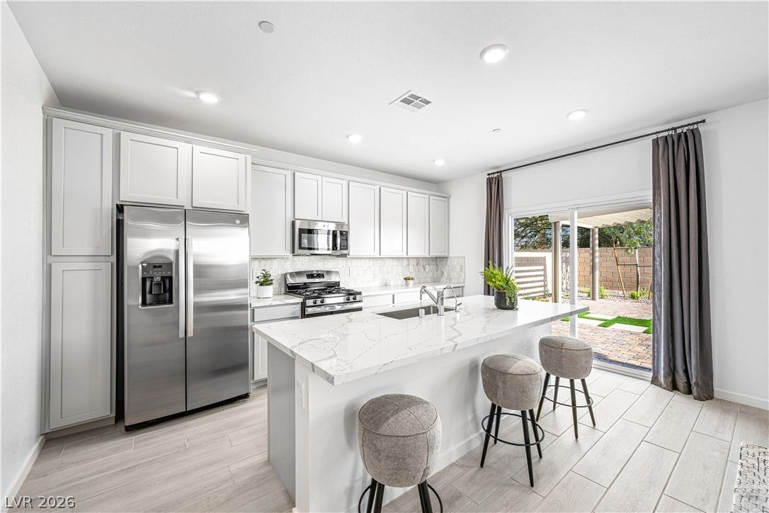 132 Harper Crest Avenue, Henderson, NV 89011 Sliding doors open to the patio from this modern culinary space featuring tile flooring.