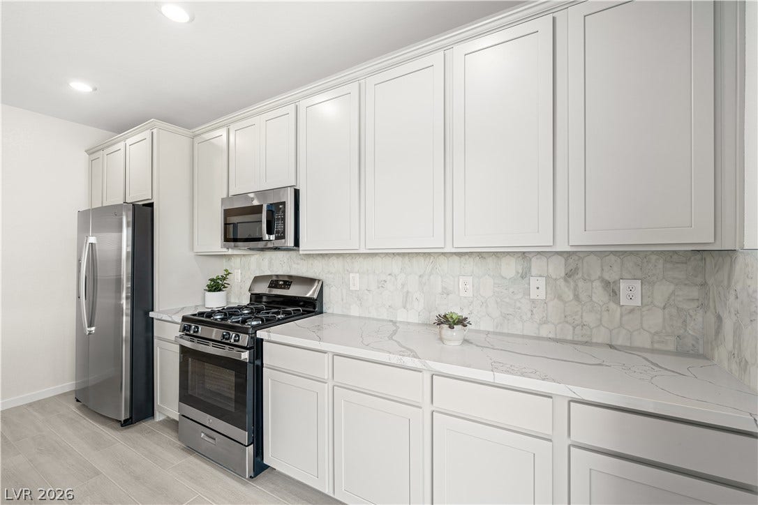 132 Harper Crest Avenue, Henderson, NV 89011 Streamlined cabinetry and veined stone countertops elevate this modern cooking space.