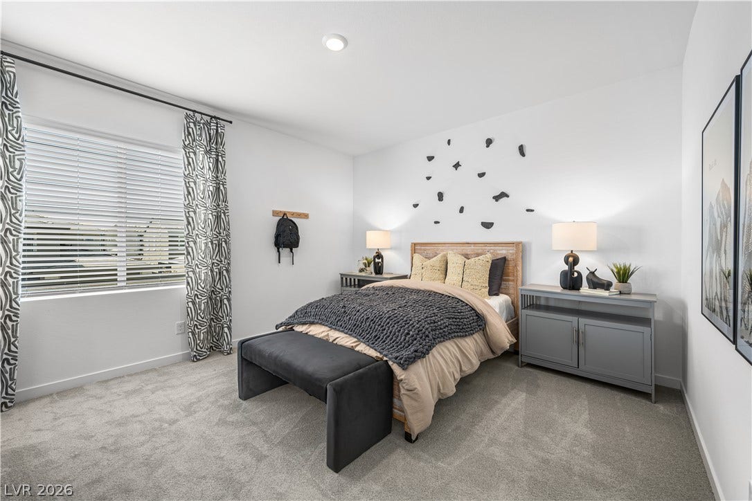 132 Harper Crest Avenue, Henderson, NV 89011 Plush carpeting and integrated lighting define this modern bedroom anchored by a large window.