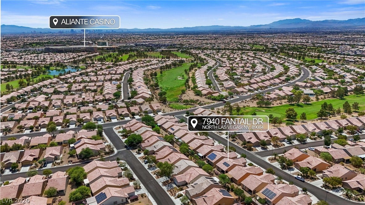 7940 Fantail Drive, North Las Vegas, NV 89084 Neighborhood aerial perspective highlights the surrounding golf course landscape and distant mountain ridges.
