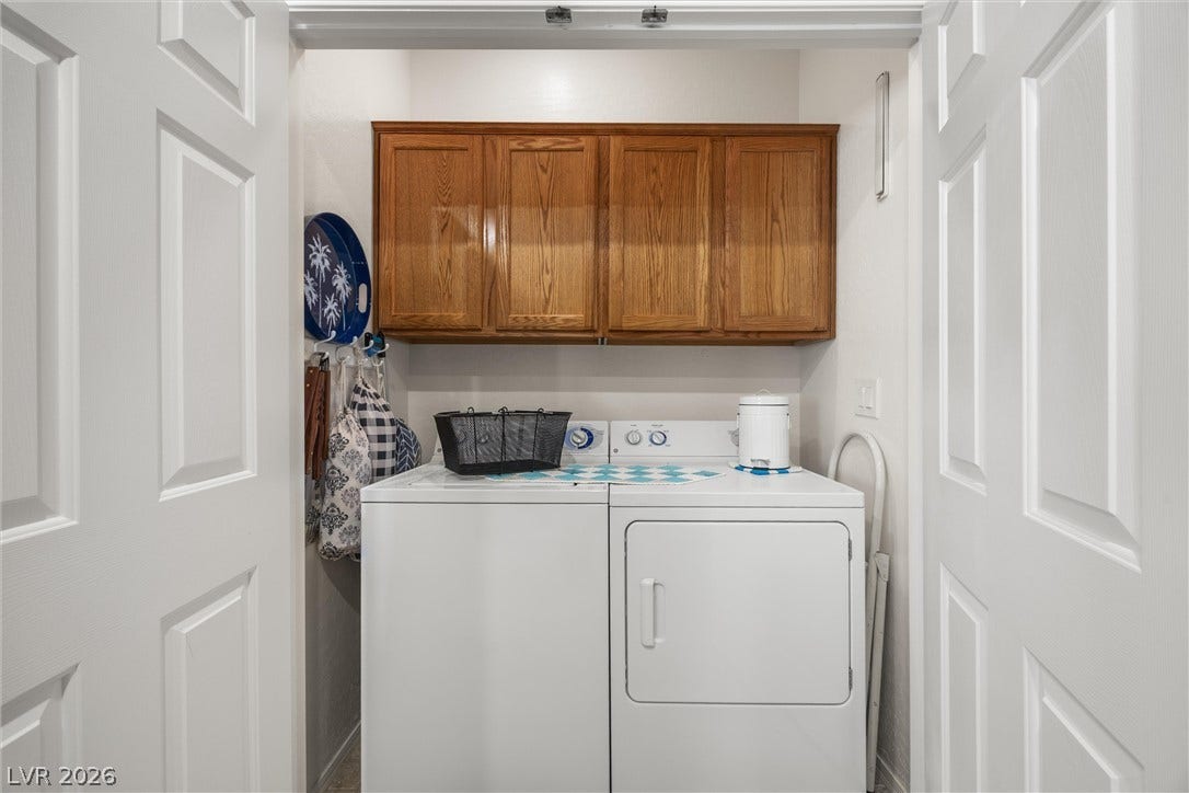7940 Fantail Drive, North Las Vegas, NV 89084 Double folding doors open to reveal a practical laundry area complete with overhead wood cabinetry.