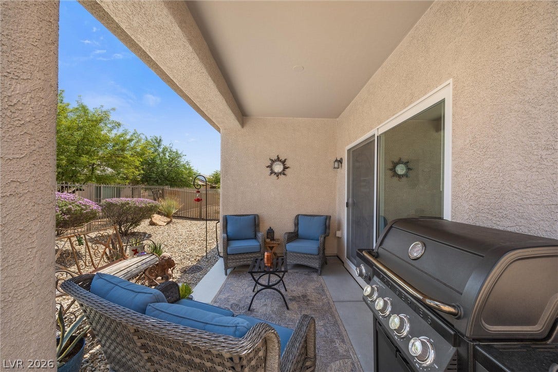 7940 Fantail Drive, North Las Vegas, NV 89084 A sheltered back patio offers stucco walls and views of the landscaped yard.