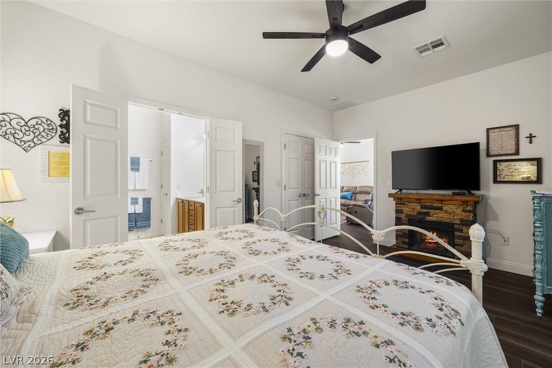 7940 Fantail Drive, North Las Vegas, NV 89084 Warmth radiates from a stone fireplace in this comfortable master suite with wood-look flooring.