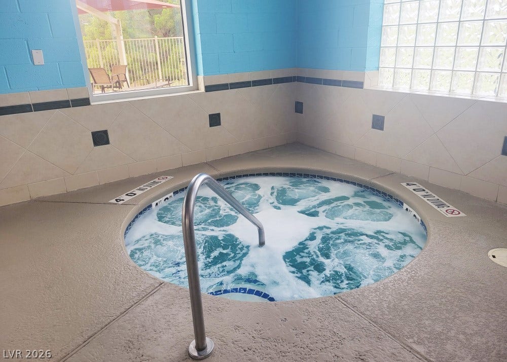 7940 Fantail Drive, North Las Vegas, NV 89084 An inviting indoor spa pool is framed by tiled walls and a large glass-block window.