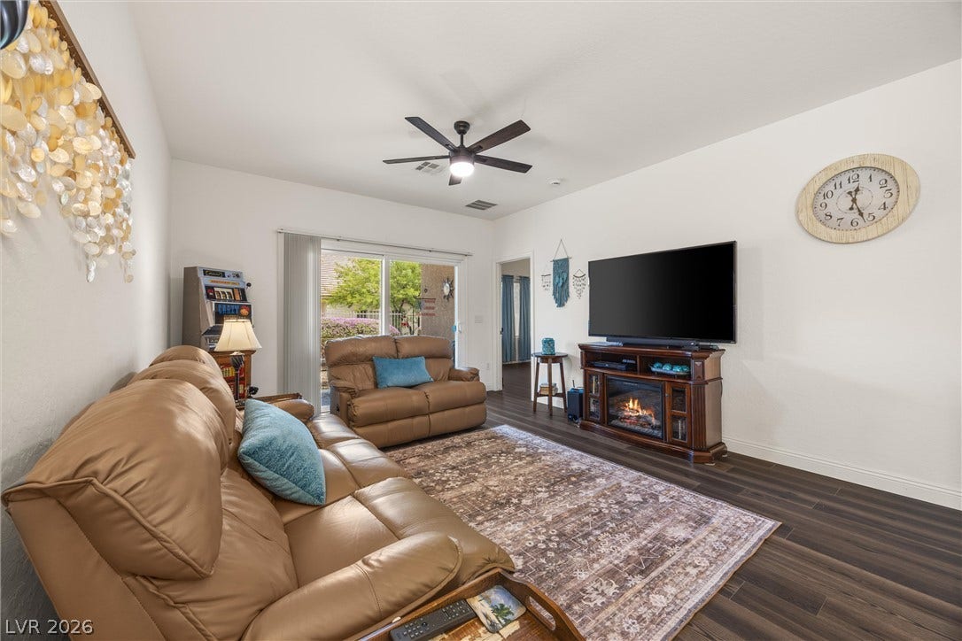7940 Fantail Drive, North Las Vegas, NV 89084 Rich wood-look flooring and a sliding glass door elevate this comfortable family living area.