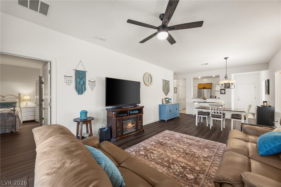 7940 Fantail Drive, North Las Vegas, NV 89084 Crisp white walls and dark wood flooring define this open-concept main level.
