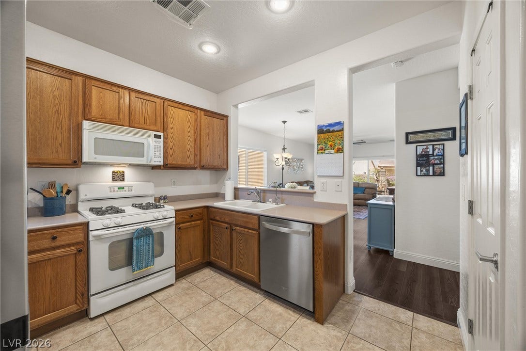 7940 Fantail Drive, North Las Vegas, NV 89084 Warm wood cabinetry and neutral tile flooring anchor this functional, open-concept kitchen space.