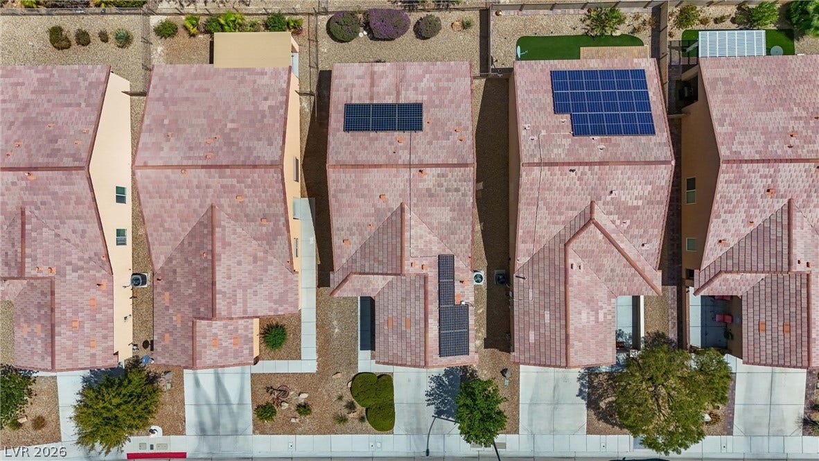 7940 Fantail Drive, North Las Vegas, NV 89084 Solar panels sit atop tiled roofs overlooking paved driveways and neat desert landscaping.