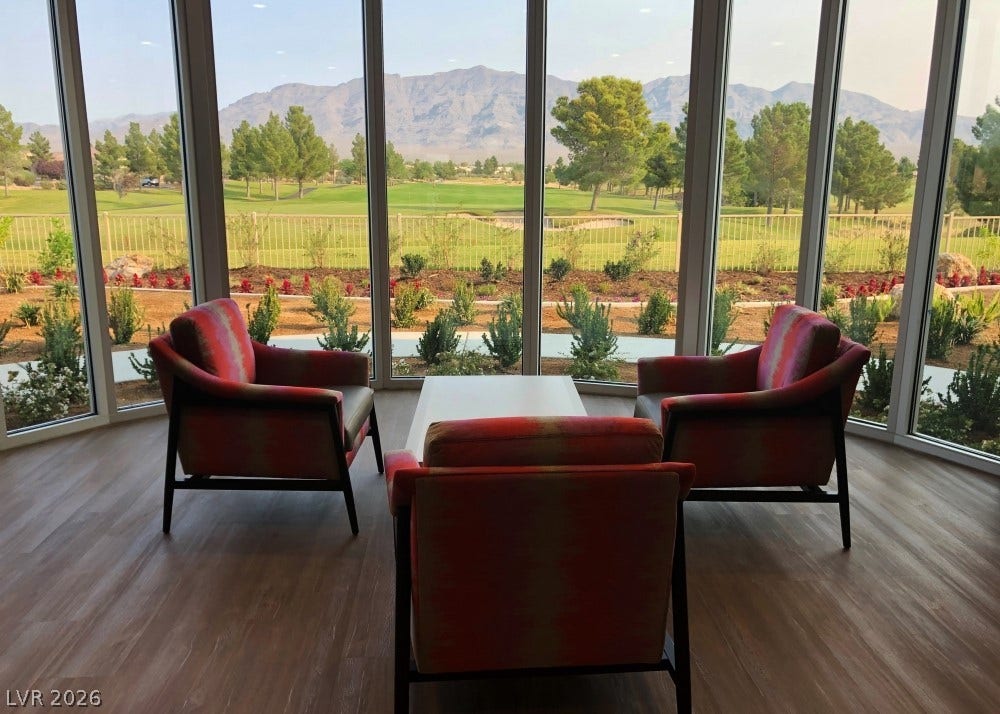7940 Fantail Drive, North Las Vegas, NV 89084 Floor-to-ceiling windows frame sweeping mountain views across a wood-look floor.