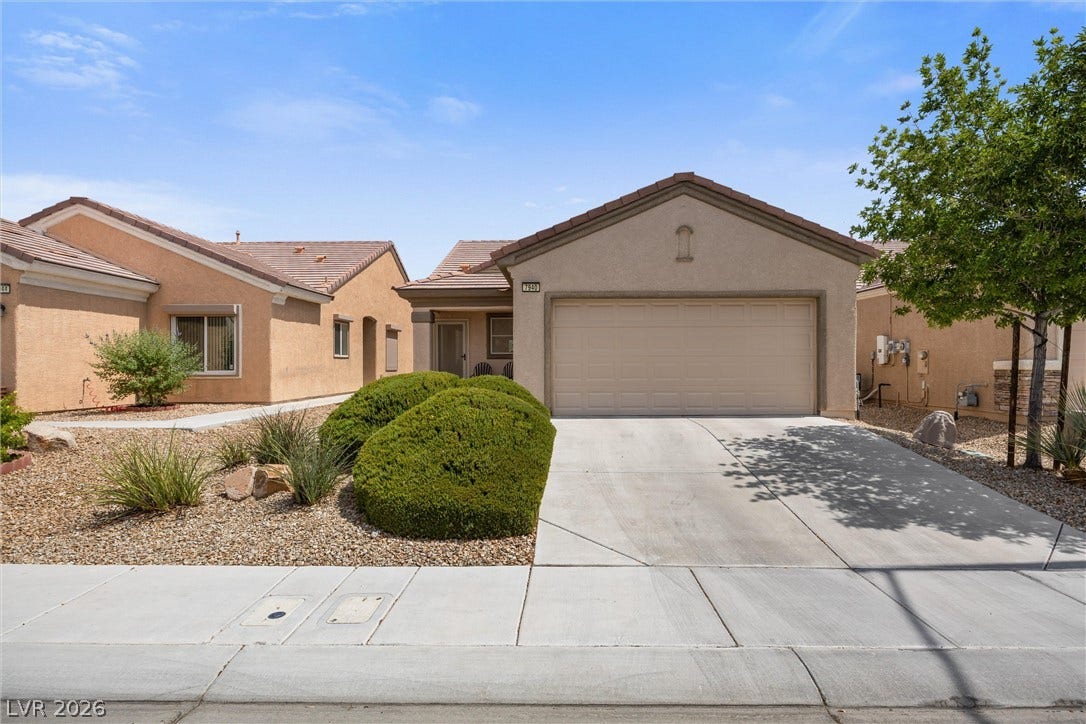 7940 Fantail Drive, North Las Vegas, NV 89084 Manicured desert landscaping frames a concrete driveway leading to the two-car garage of this stucco home.