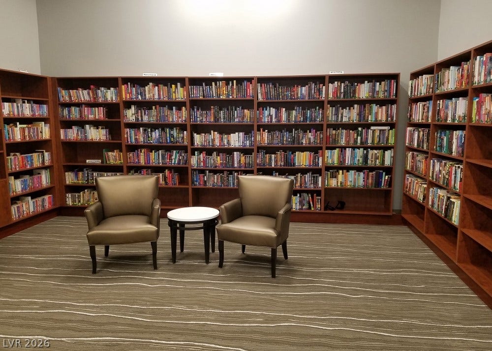 7940 Fantail Drive, North Las Vegas, NV 89084 Floor-to-ceiling wooden bookcases surround a comfortable reading area on patterned carpeting.