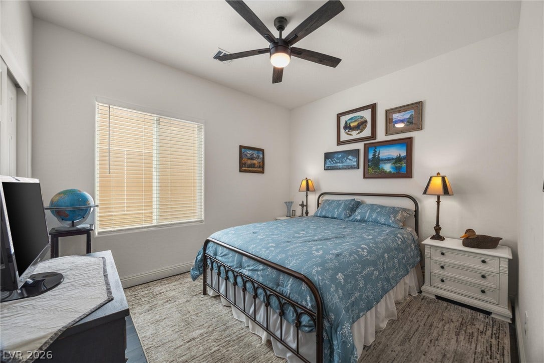 7940 Fantail Drive, North Las Vegas, NV 89084 Bedroom 2; Natural light from a large window illuminates this comfortable bedroom featuring wood-look flooring.