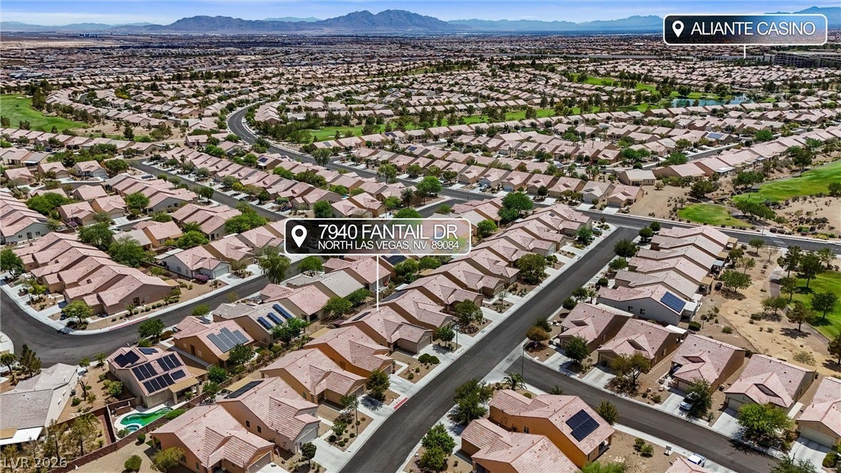 7940 Fantail Drive, North Las Vegas, NV 89084 An aerial perspective showcases a quiet residential neighborhood set against a backdrop of distant mountains.