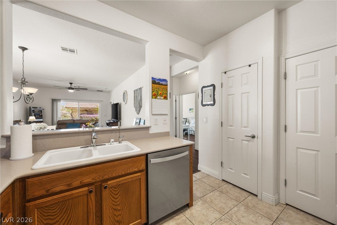 7940 Fantail Drive, North Las Vegas, NV 89084 An open pass-through looks out from the tiled kitchen toward the main living space.