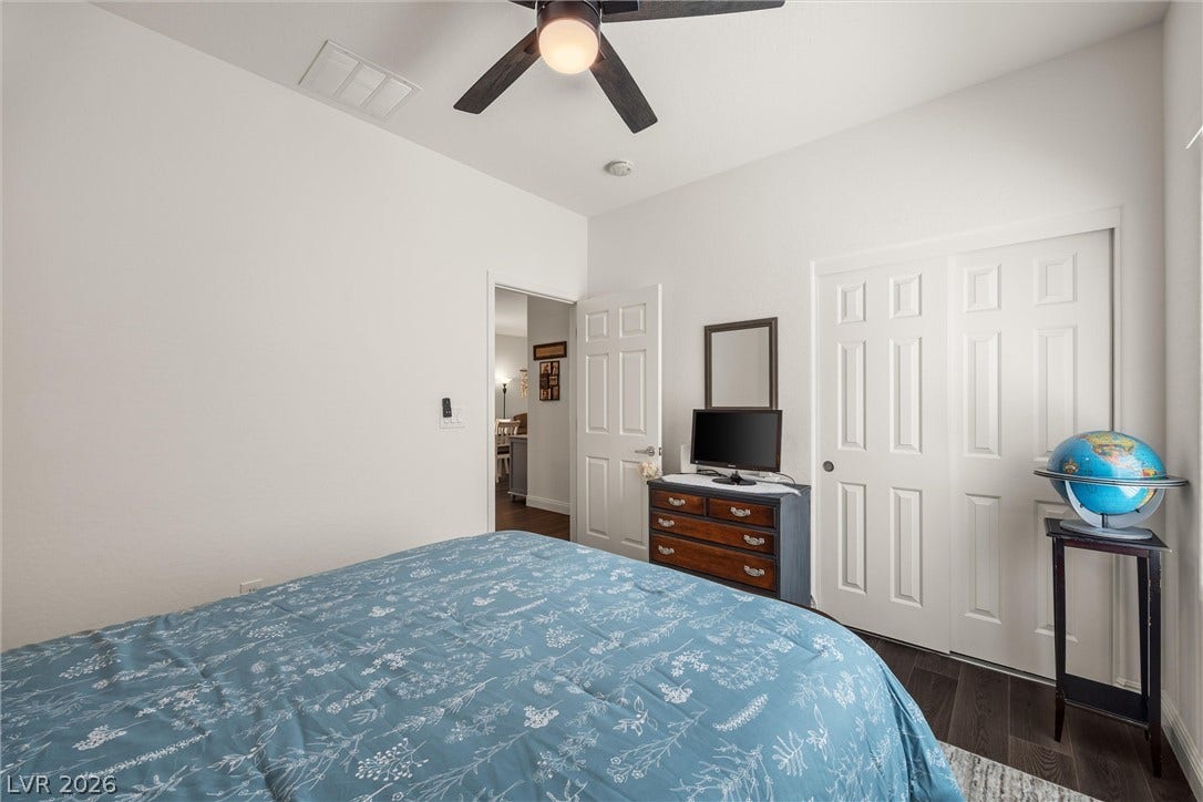 7940 Fantail Drive, North Las Vegas, NV 89084 Bedroom 2: High ceilings and rich dark wood flooring define this serene and private bedroom space.